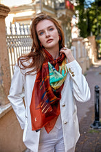Load image into Gallery viewer, Discover the harmony of tradition and contemporary elegance with this timeless wool shawl. This large hand-stitched shawl radiates warmth through its tones of red, orange, green, blue sunset colours, evoking a vibrant energy and life-giving power.