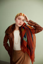Load image into Gallery viewer, Discover the harmony of tradition and contemporary elegance with this timeless wool shawl. This large hand-stitched shawl radiates warmth through its tones of red, orange, green, blue sunset colours, evoking a vibrant energy and life-giving power.