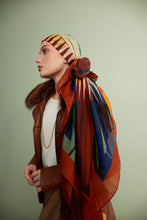 Load image into Gallery viewer, Discover the harmony of tradition and contemporary elegance with this timeless wool shawl. This large hand-stitched shawl radiates warmth through its tones of red, orange, green, blue sunset colours, evoking a vibrant energy and life-giving power.