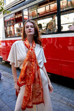 Load image into Gallery viewer, Discover the harmony of tradition and contemporary elegance with this timeless crepe silk shawl. This large shawl radiates warmth through its red, orange and beige sunset colours, evoking a vibrant energy and life-giving power.
