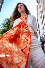 Load image into Gallery viewer, Discover the harmony of tradition and contemporary elegance with this timeless crepe silk shawl. This large shawl radiates warmth through its red, orange and beige sunset colours, evoking a vibrant energy and life-giving power.